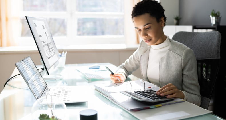 a woman using a calculator at her desk