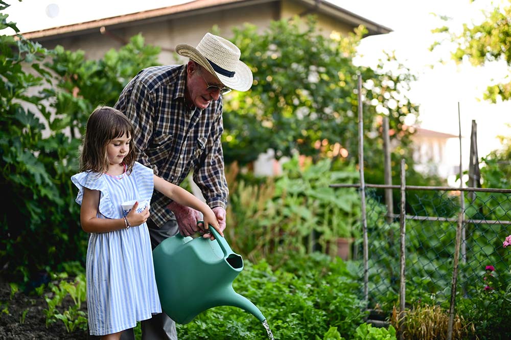 Grandfather gardening with grandchild overcoming parkinsons