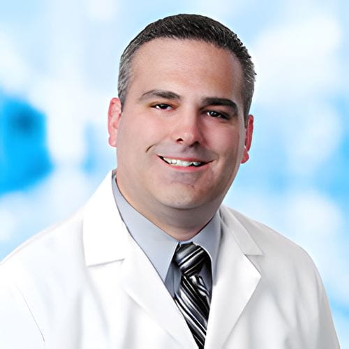 Headshot of Dr Tricarico on white and blue background