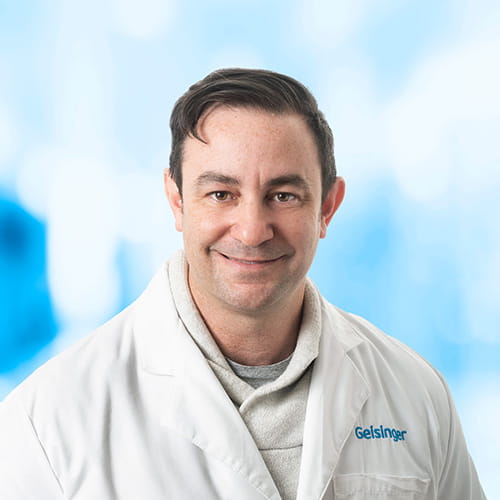 Headshot of Dr Keen on white and blue background