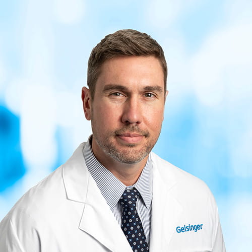 Headshot of Dr Sluck on white and blue background