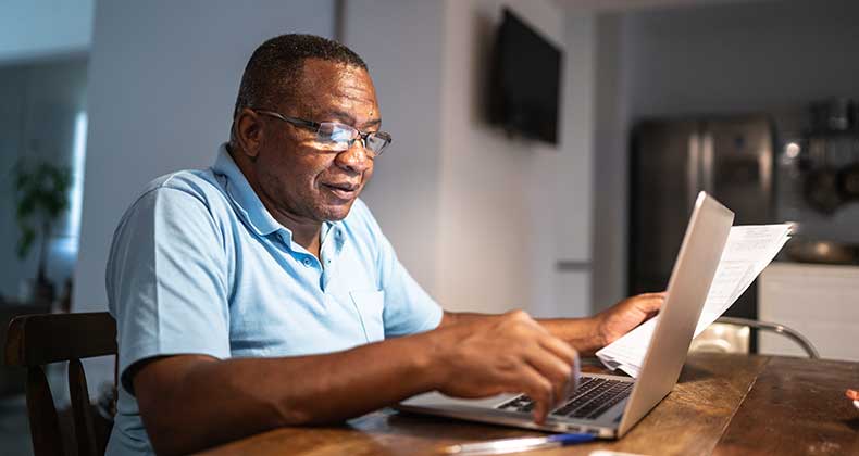 An older gentlemen paying his bills online