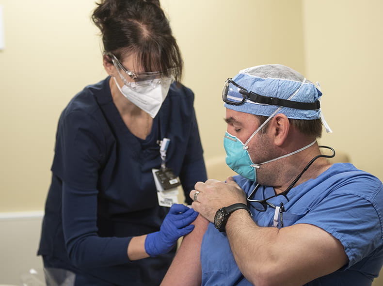 Health worker giving a COVID-19 vaccine