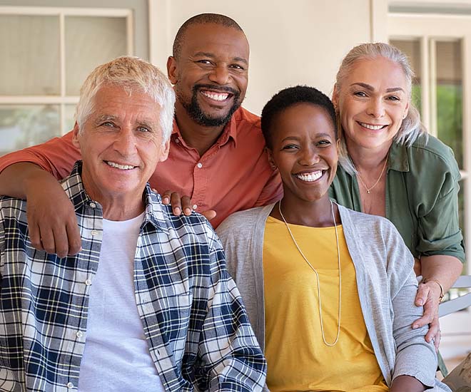 Two couples gather together on the front porch for a candid photo.