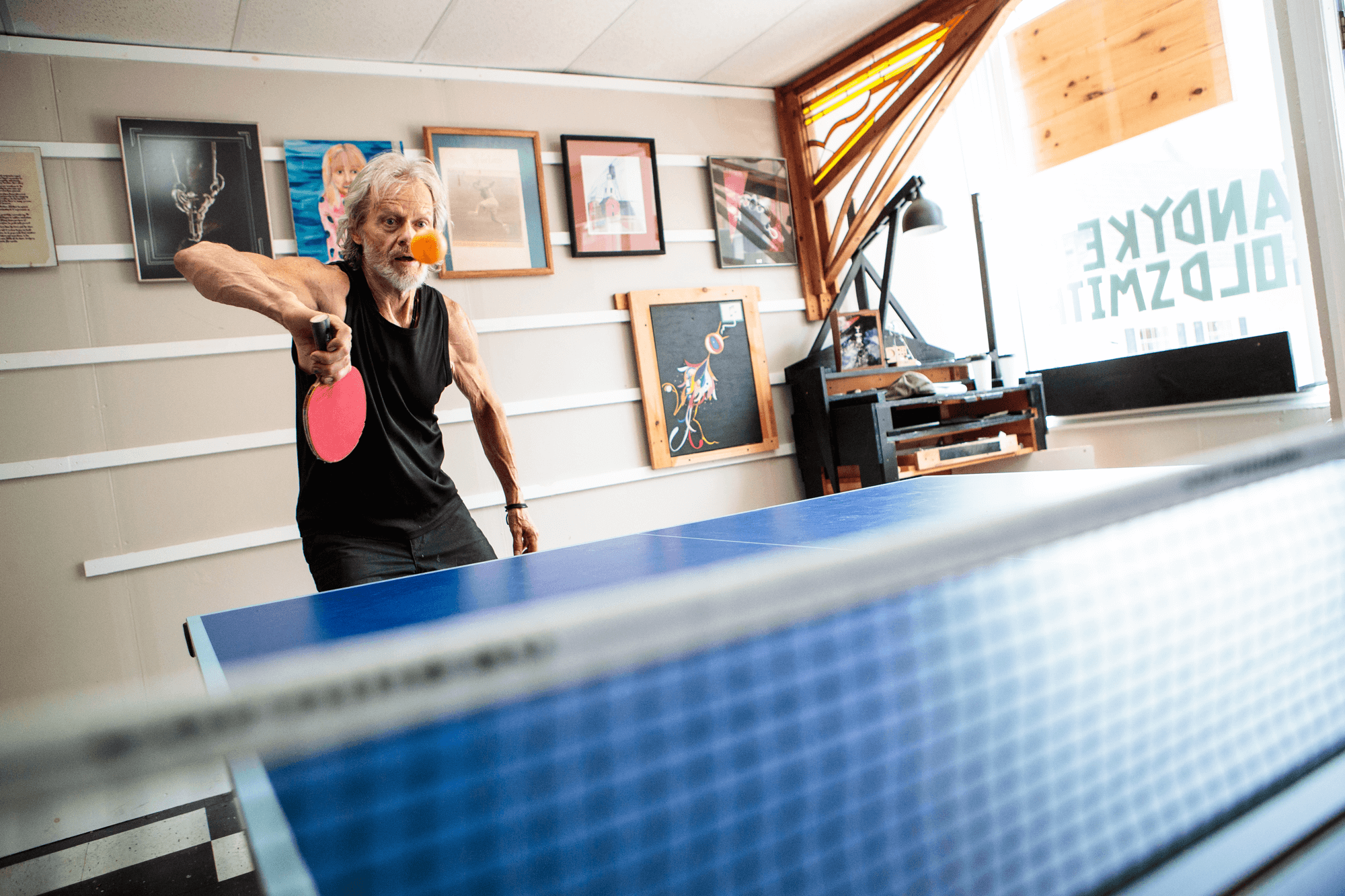 An older man playing ping-pong